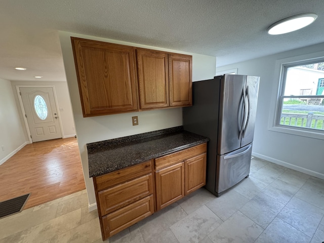 29 Faith St, Lisbon, ME 04252 - kitchen with freestanding refrigerator, brown cabinets, baseboards, dark stone counters, and recessed lighting