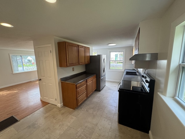 29 Faith St, Lisbon, ME 04252 - kitchen featuring electric range, a sink, brown cabinets, baseboards, and freestanding refrigerator