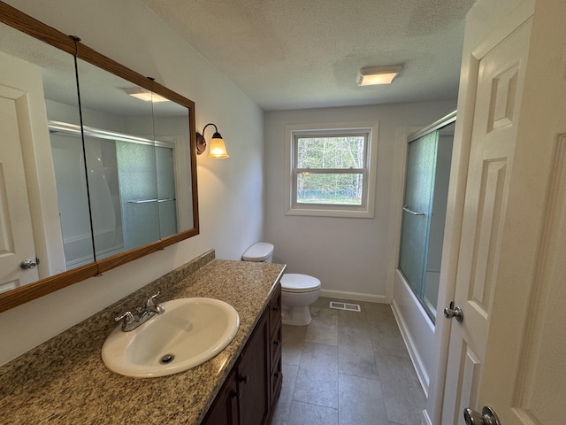 29 Faith St, Lisbon, ME 04252 - bathroom with a textured ceiling, vanity, toilet, shower / bath combination with glass door, and baseboards