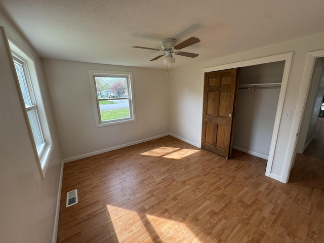 29 Faith St, Lisbon, ME 04252 - unfurnished bedroom with light wood-style floors, a closet, baseboards, a ceiling fan, and a textured ceiling