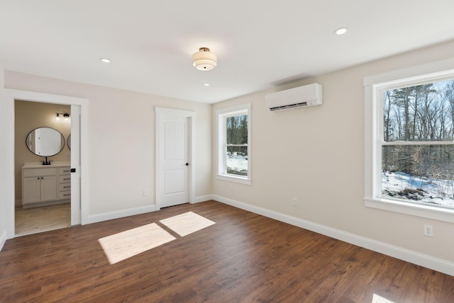 1540 Foxes Ridge Rd, Acton, ME 04001 - unfurnished bedroom featuring a wall mounted AC, baseboards, wood finished floors, recessed lighting, and a sink