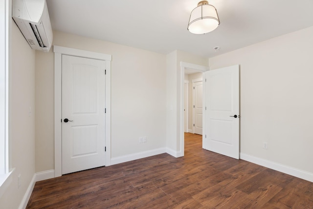 1540 Foxes Ridge Rd, Acton, ME 04001 - unfurnished bedroom featuring a wall mounted air conditioner, dark wood-style flooring, and baseboards
