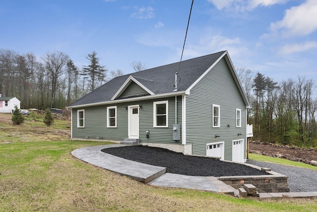 1540 Foxes Ridge Rd, Acton, ME 04001 - back of property featuring a garage, a shingled roof, a lawn, and driveway