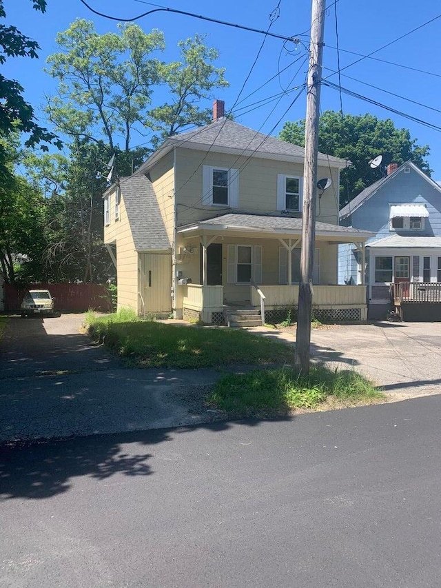 91 Elm St, Millinocket, ME 04462 - traditional style home with covered porch, a chimney, a shingled roof, and fence