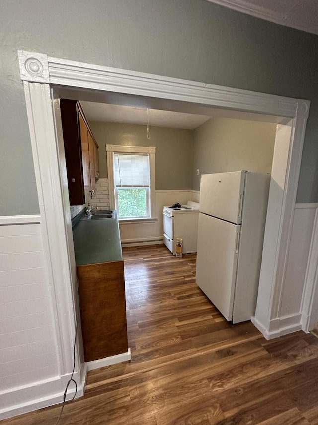 91 Elm St, Millinocket, ME 04462 - kitchen with white appliances, dark wood-style floors, wainscoting, and a sink