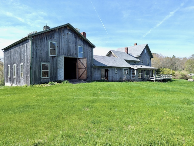 99 W Hamlet Rd, Newcastle, ME 04553 - rear view of property featuring a chimney, a barn, a lawn, and an outbuilding