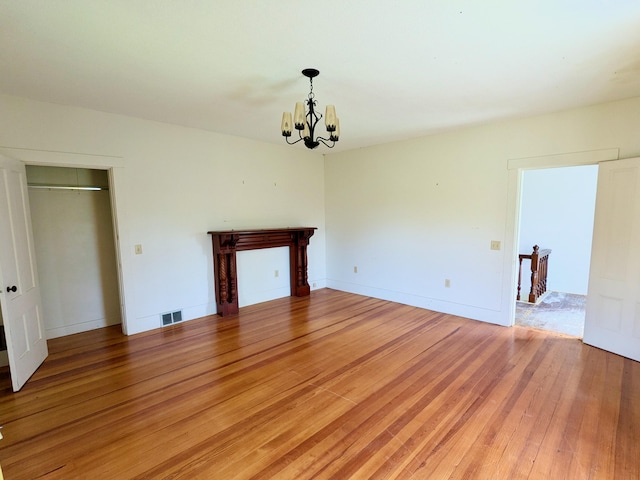 99 W Hamlet Rd, Newcastle, ME 04553 - unfurnished living room featuring a chandelier and light wood finished floors