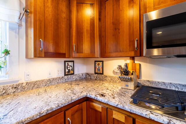 372 Pettegrow Point Rd, Machiasport, ME 04655 - kitchen with appliances with stainless steel finishes, light stone counters, and brown cabinetry