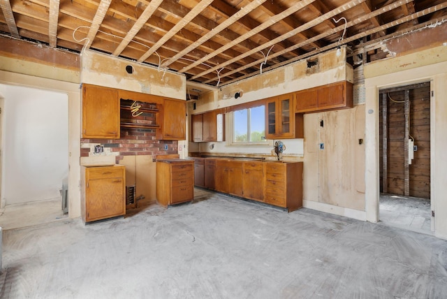 244 Concord St W, Portland, ME 04103 - kitchen with brown cabinets, unfinished concrete floors, and glass insert cabinets