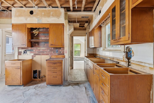 244 Concord St W, Portland, ME 04103 - kitchen featuring unfinished concrete floors, brown cabinetry, and glass insert cabinets