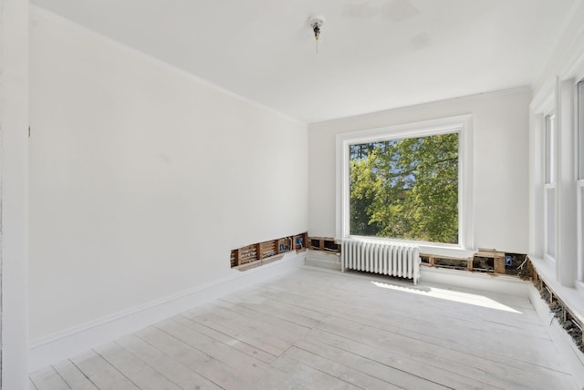 244 Concord St W, Portland, ME 04103 - empty room with radiator, ornamental molding, and wood finished floors