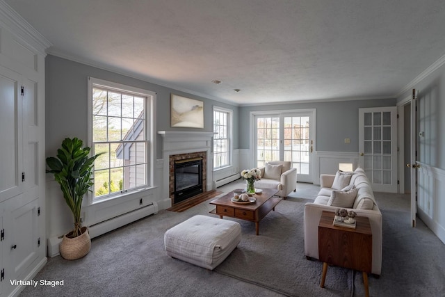 9 Ocean View Cir, Saco, ME 04072 - carpeted living room with a baseboard radiator, ornamental molding, healthy amount of natural light, a glass covered fireplace, and a wainscoted wall