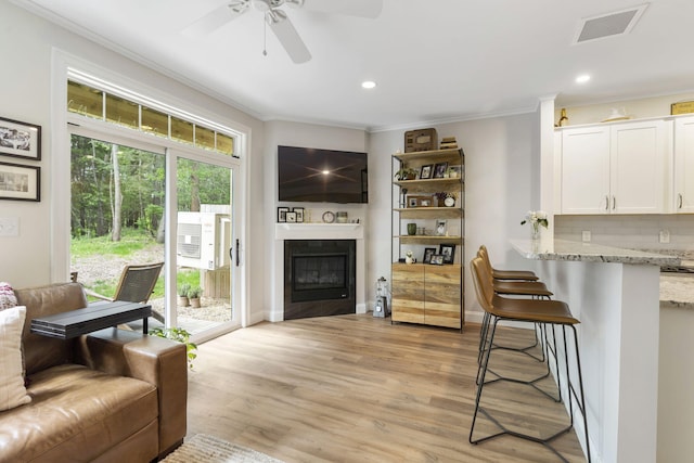 25 Preservation Ln Unit 9, South Portland, ME 04106 - living area with crown molding, ceiling fan, a glass covered fireplace, recessed lighting, and light wood-style flooring