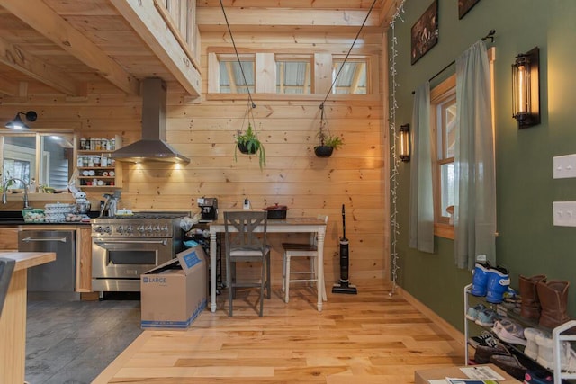 26 Christen Rd, Kingfield, ME 04947 - kitchen featuring appliances with stainless steel finishes, island exhaust hood, wooden walls, light wood finished floors, and open shelves