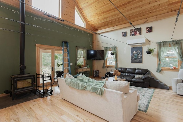 26 Christen Rd, Kingfield, ME 04947 - living room featuring a wood stove, wood ceiling, high vaulted ceiling, wood-type flooring, and a wall unit AC