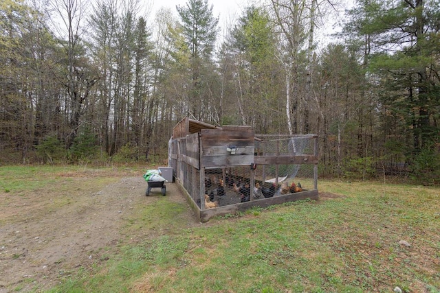 26 Christen Rd, Kingfield, ME 04947 - view of yard with exterior structure, a forest view, driveway, and an outbuilding