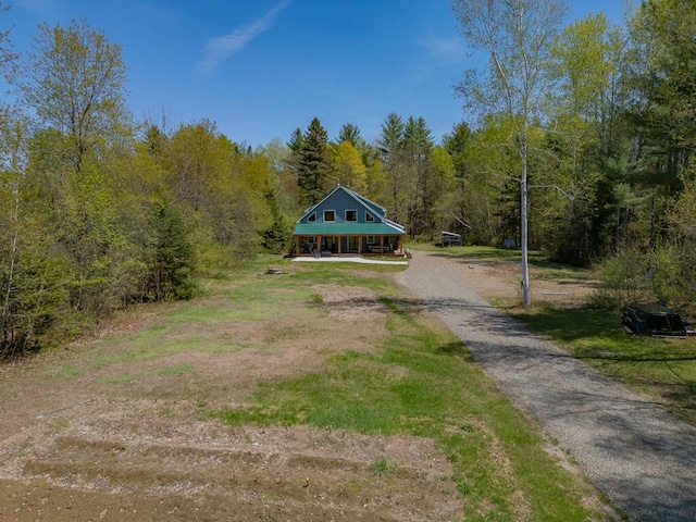 26 Christen Rd, Kingfield, ME 04947 - view of front facade with covered porch, asphalt driveway, and a wooded view
