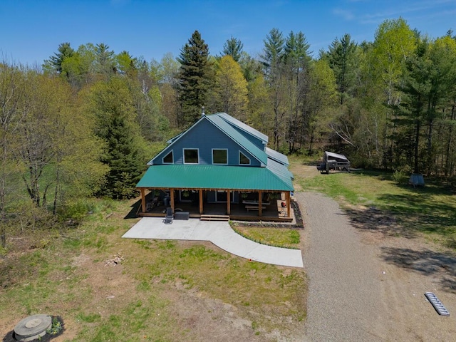 26 Christen Rd, Kingfield, ME 04947 - rustic home featuring metal roof, a wooded view, and covered porch
