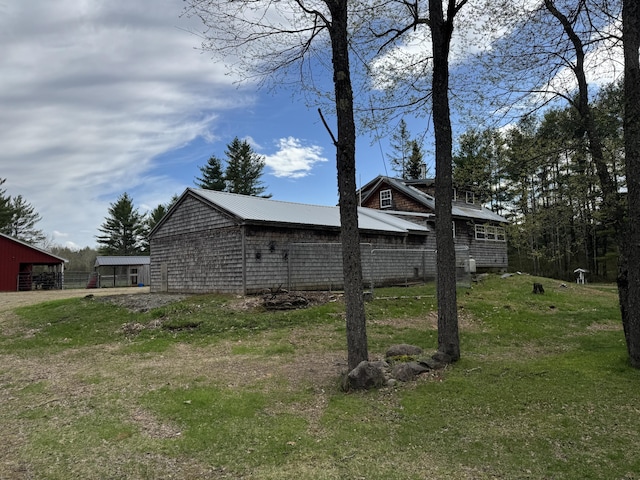 7 Howard Siding Ln, Abbot, ME 04406 - view of side of home featuring a lawn, a pole building, metal roof, and an outdoor structure