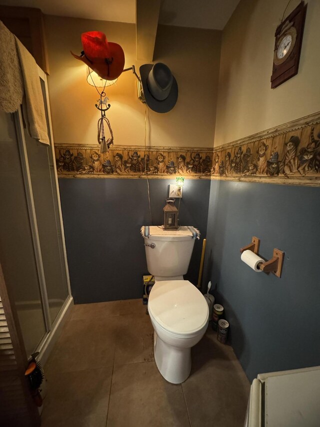 7 Howard Siding Ln, Abbot, ME 04406 - bathroom featuring toilet, a shower stall, a wainscoted wall, and tile patterned flooring