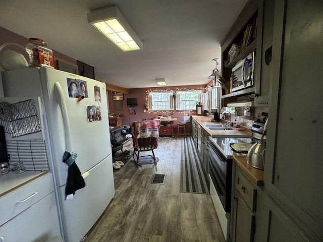 7 Howard Siding Ln, Abbot, ME 04406 - kitchen featuring electric range, stainless steel microwave, dark wood finished floors, a sink, and freestanding refrigerator