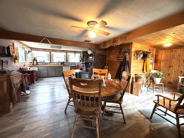 7 Howard Siding Ln, Abbot, ME 04406 - dining space featuring ceiling fan, wood walls, a textured ceiling, and wood finished floors