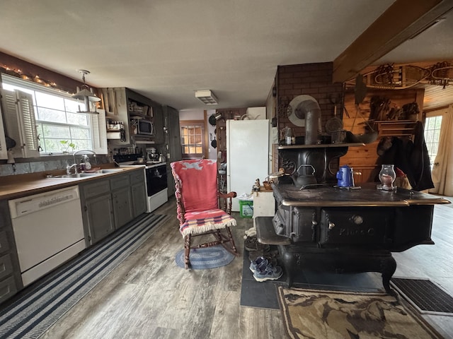 7 Howard Siding Ln, Abbot, ME 04406 - kitchen featuring white appliances, a sink, a wood stove, wood finished floors, and open shelves