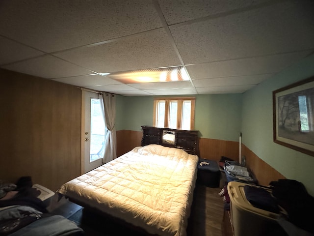 7 Howard Siding Ln, Abbot, ME 04406 - bedroom featuring wooden walls, a drop ceiling, wood finished floors, and wainscoting