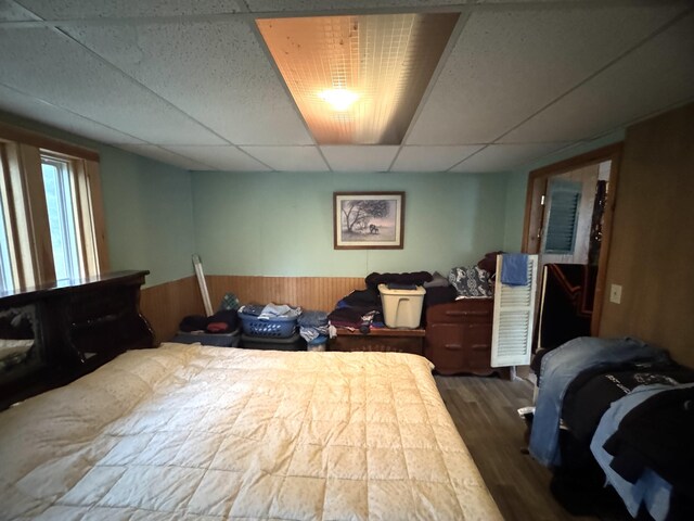 7 Howard Siding Ln, Abbot, ME 04406 - bedroom featuring a drop ceiling, wainscoting, wood finished floors, and wood walls