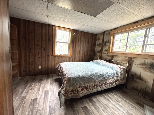 7 Howard Siding Ln, Abbot, ME 04406 - bedroom featuring multiple windows, a paneled ceiling, wood finished floors, and wood walls