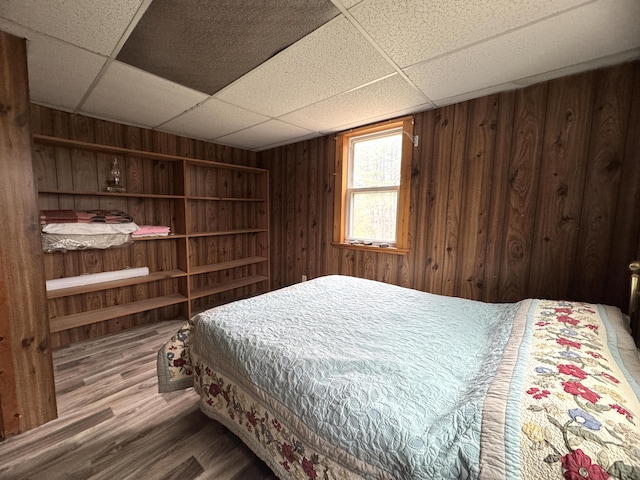 7 Howard Siding Ln, Abbot, ME 04406 - bedroom featuring a drop ceiling, wood finished floors, and wood walls