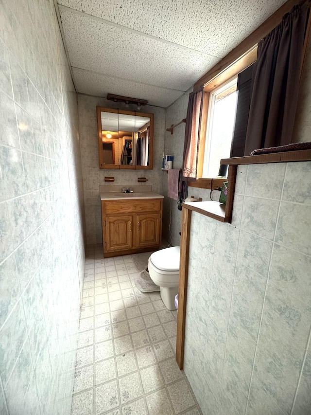 7 Howard Siding Ln, Abbot, ME 04406 - bathroom featuring tile patterned floors, toilet, a paneled ceiling, and vanity