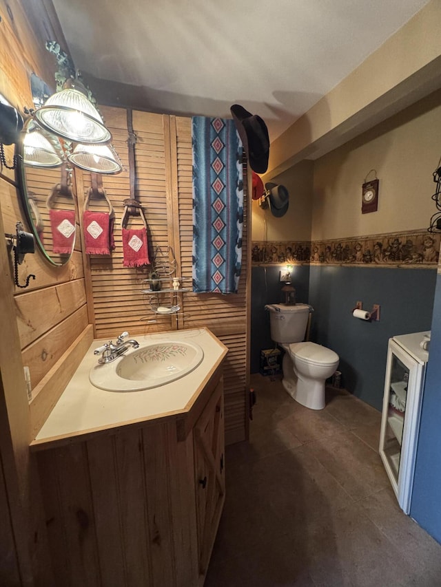 7 Howard Siding Ln, Abbot, ME 04406 - half bathroom featuring toilet, a wainscoted wall, vanity, and wood walls