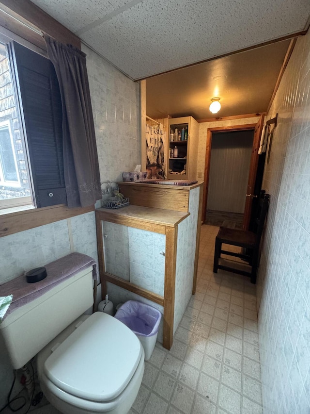 7 Howard Siding Ln, Abbot, ME 04406 - bathroom featuring tile patterned floors, toilet, and tile walls