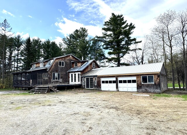 7 Howard Siding Ln, Abbot, ME 04406 - shingle-style home with an attached garage, a sunroom, metal roof, and a deck