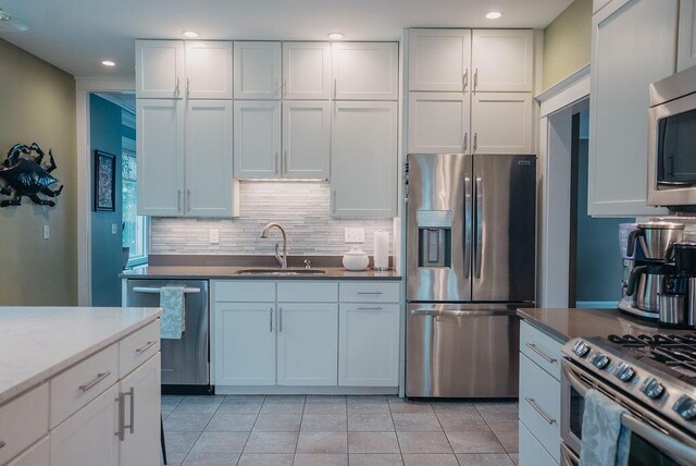 107 Maple St, Bangor, ME 04401 - kitchen featuring appliances with stainless steel finishes, a sink, tasteful backsplash, white cabinets, and recessed lighting