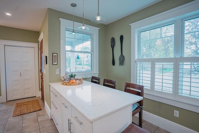 107 Maple St, Bangor, ME 04401 - kitchen with healthy amount of natural light, white cabinets, and light tile patterned floors