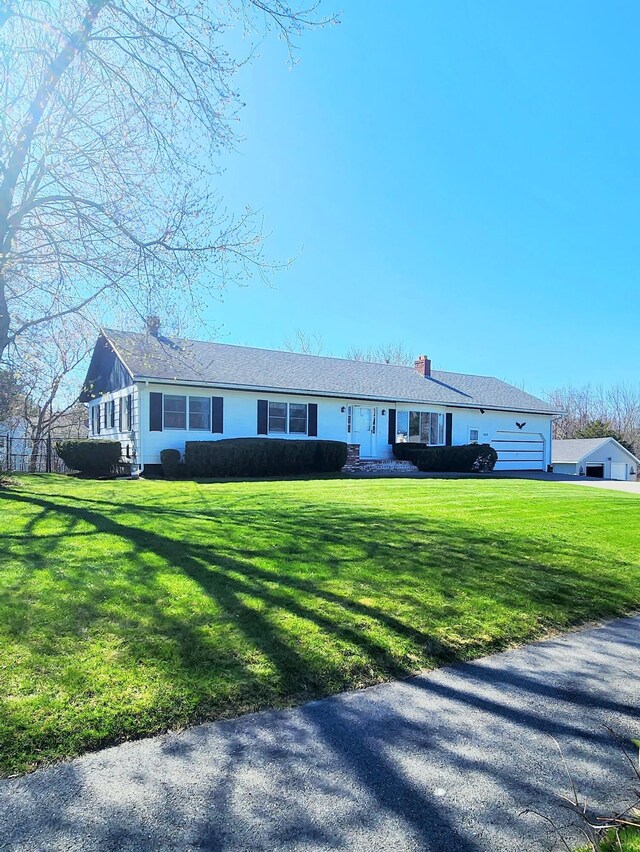 single story home with a chimney and a front lawn
