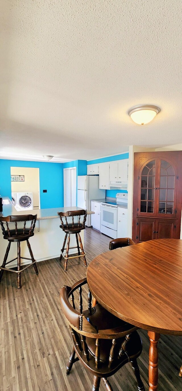 dining space featuring a textured ceiling and wood finished floors