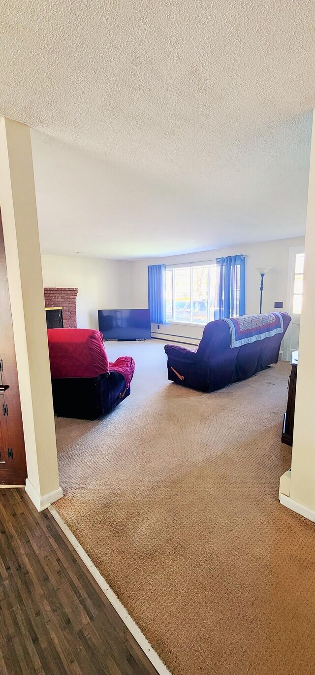 carpeted bedroom featuring multiple windows, a fireplace, a textured ceiling, wood finished floors, and baseboards