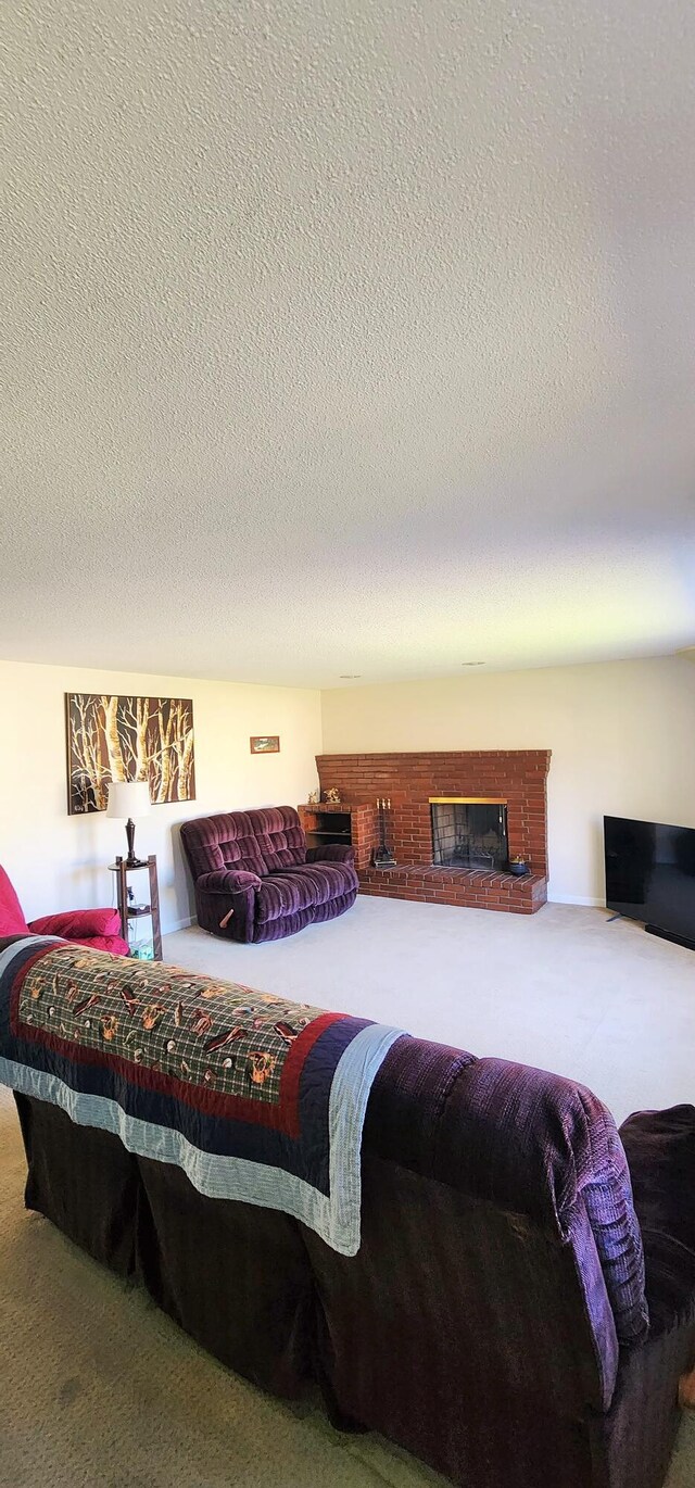 carpeted bedroom featuring a textured ceiling and a fireplace