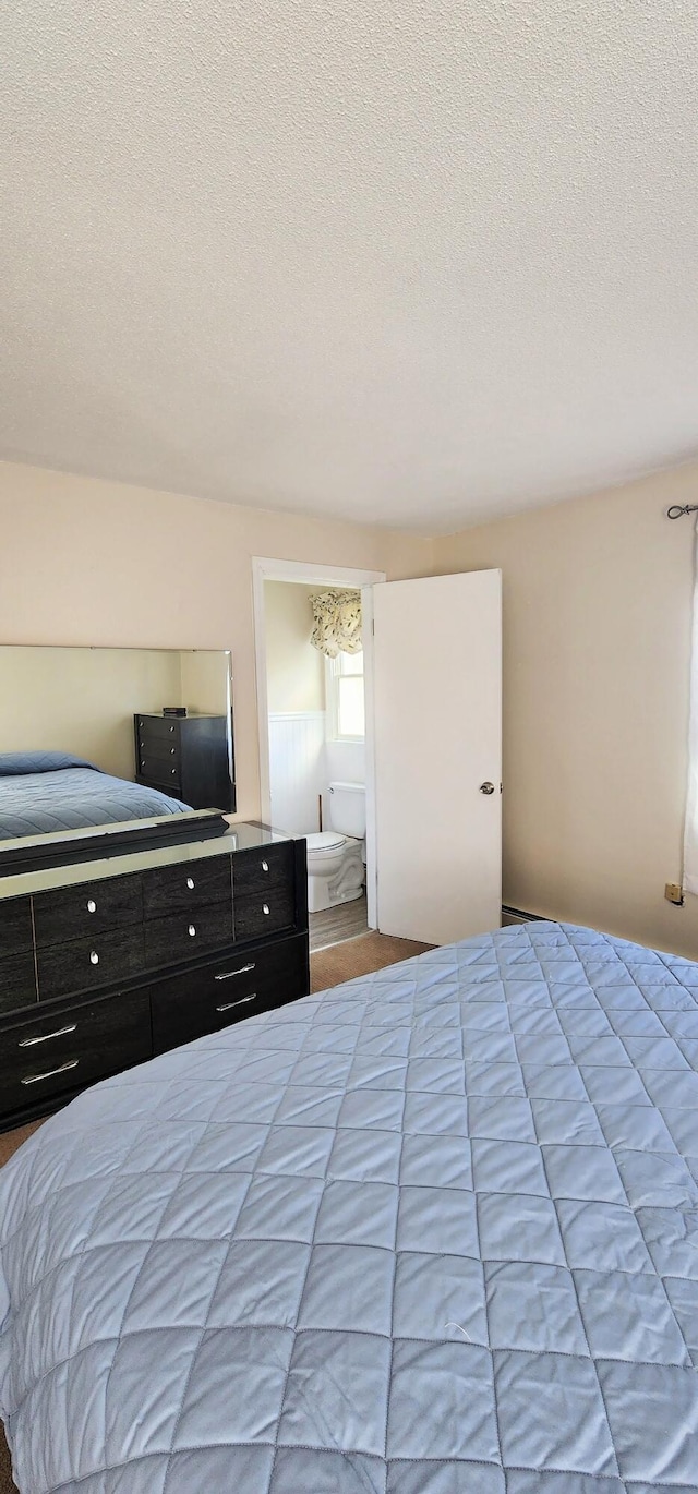 bedroom featuring a textured ceiling and connected bathroom