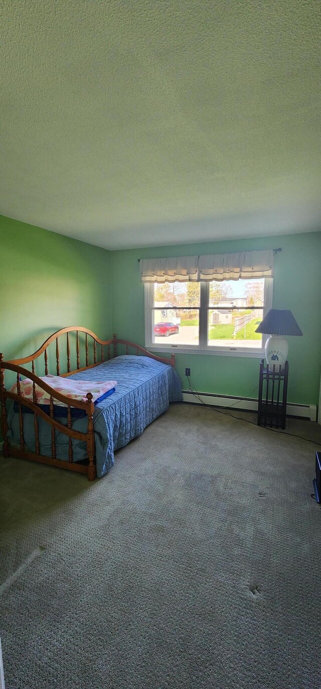 bedroom with carpet flooring, a textured ceiling, and baseboard heating