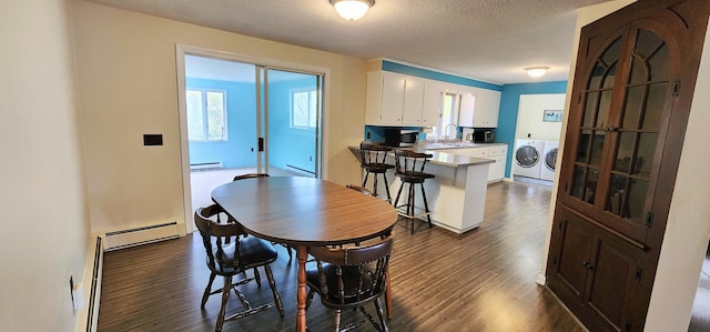 400 Birch St, Bangor, ME 04401 - dining area with washer and clothes dryer, a baseboard radiator, dark wood-style floors, baseboard heating, and a textured ceiling