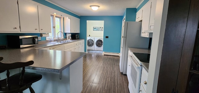 400 Birch St, Bangor, ME 04401 - kitchen featuring separate washer and dryer, white appliances, a sink, baseboard heating, and white cabinetry