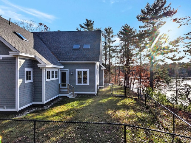 rear view of property with a shingled roof and entry steps