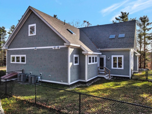 back of house with entry steps, central AC, and roof with shingles