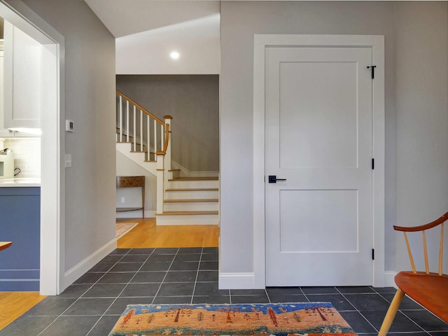 stairway featuring tile patterned flooring, baseboards, and recessed lighting