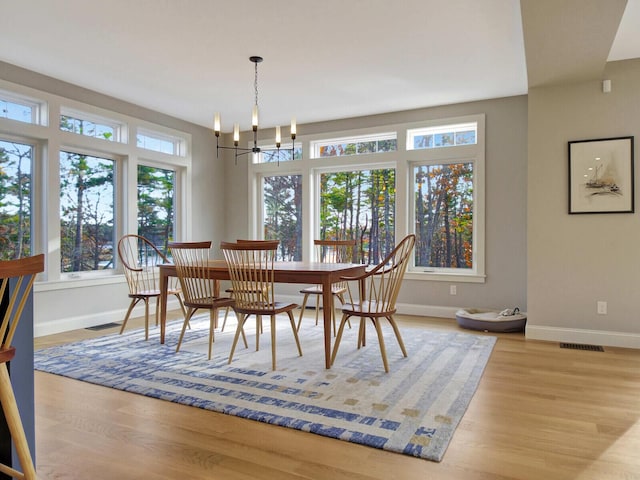 dining room featuring baseboards, wood finished floors, and a chandelier