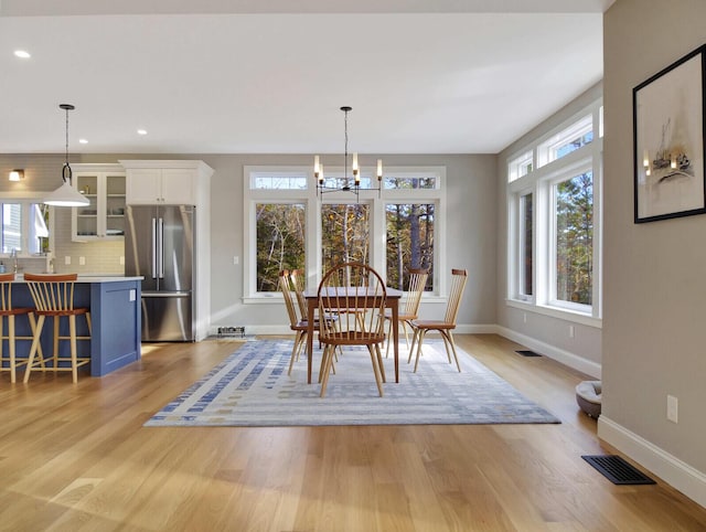 dining area featuring baseboards, a chandelier, light wood finished floors, and recessed lighting